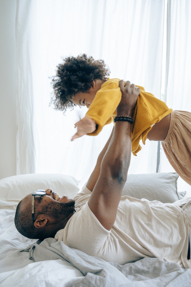 Seguro d vida papa e hijo felices sobre la cama