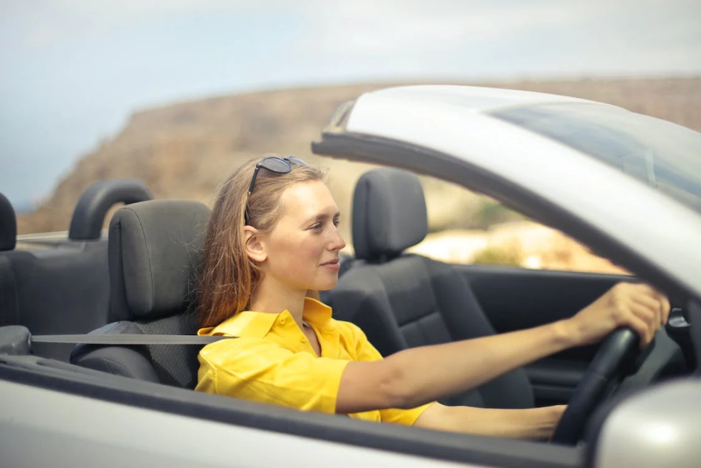 licencia conducir mujer con camisa amarilla conduciendo en carretera